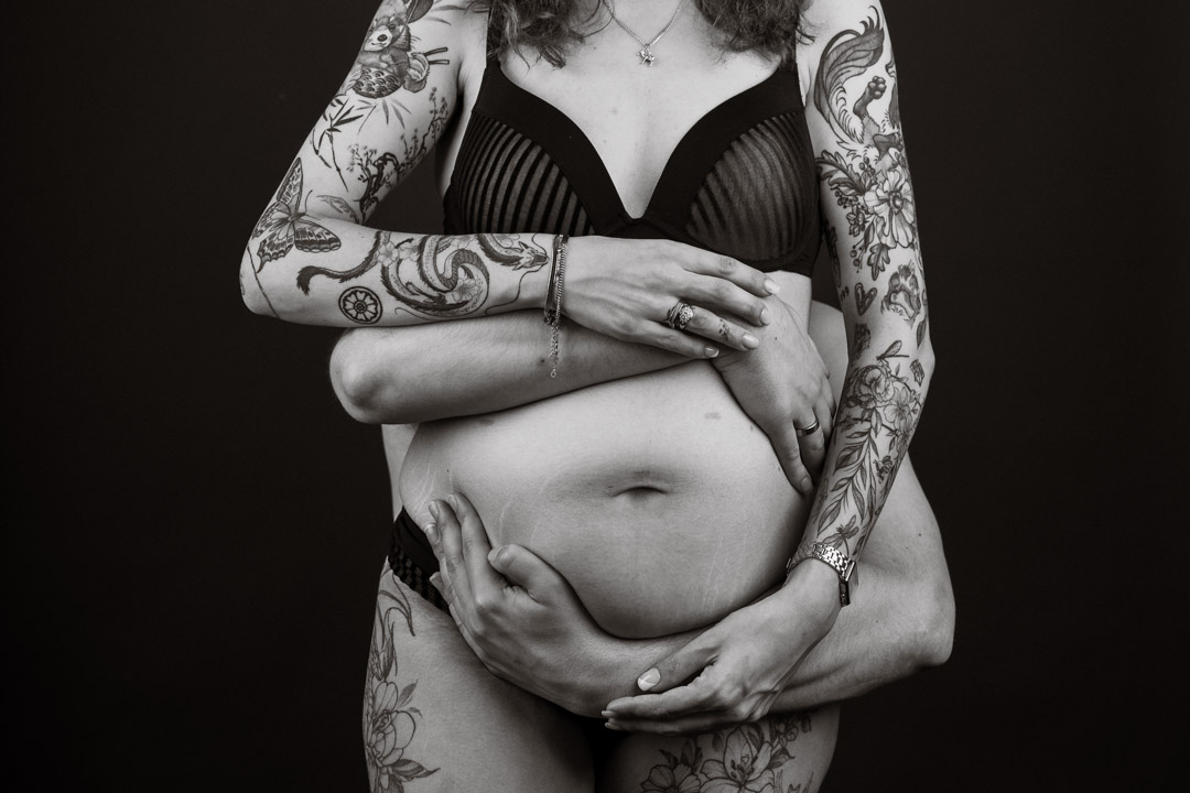 zwangerschapsfotografie artistiek met handen van de vader en moeder