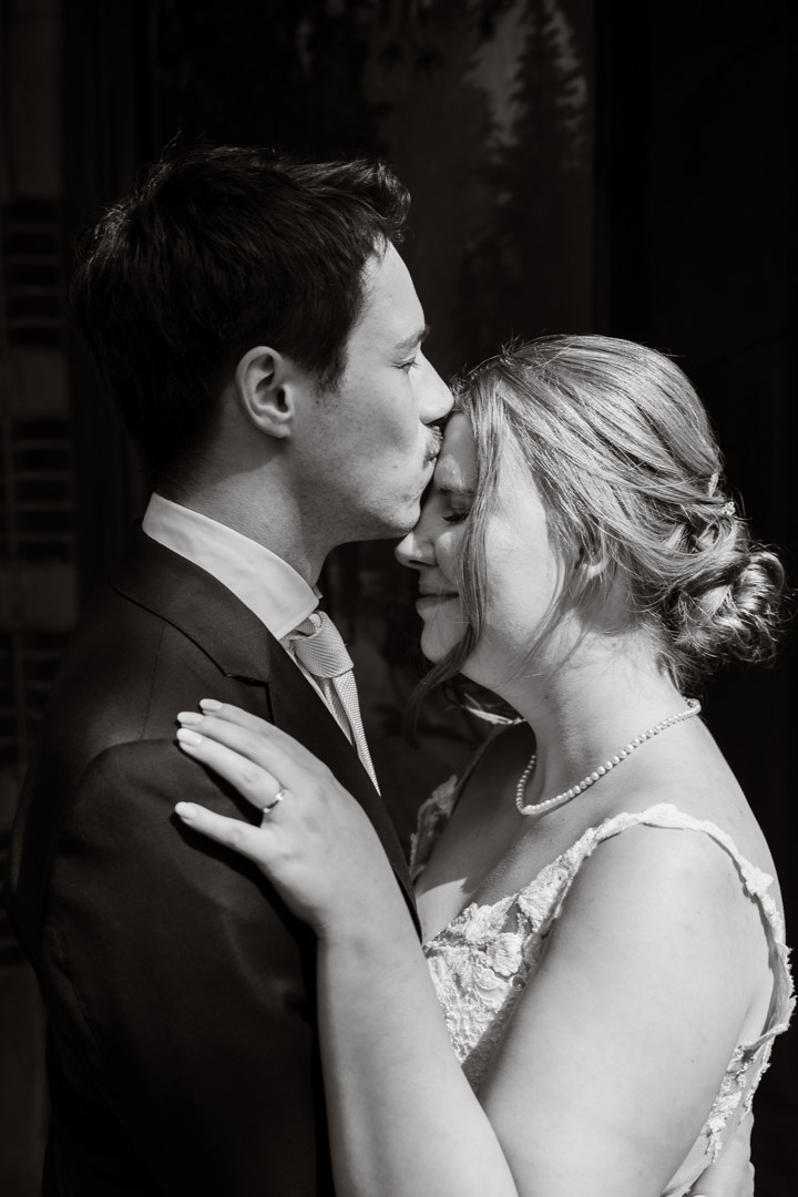 trouwfotografie, man geeft vrouw kus op haar voorhoofd