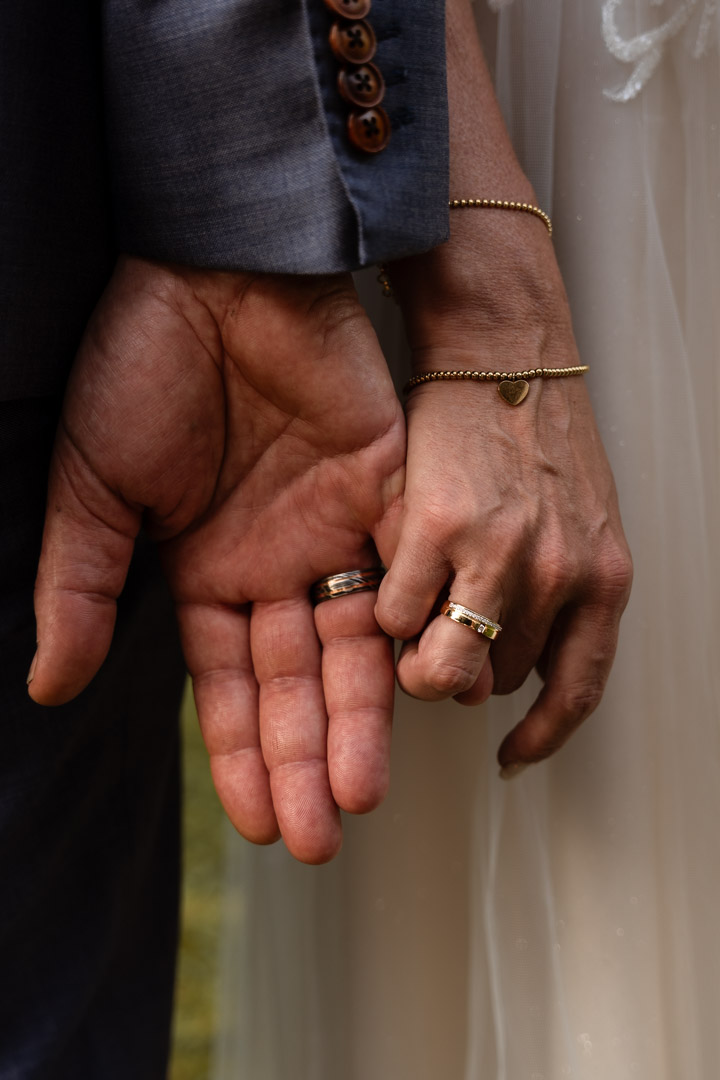 trouwfotografie van ringen aan de handen van het bruidspaar